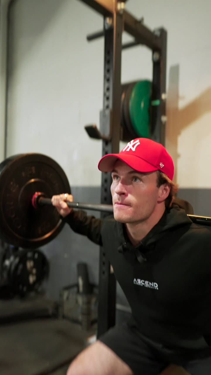 Squatting with a barbell in the gym